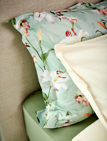 detail shot van een hoofdkussen in een groene kleur met bloemen