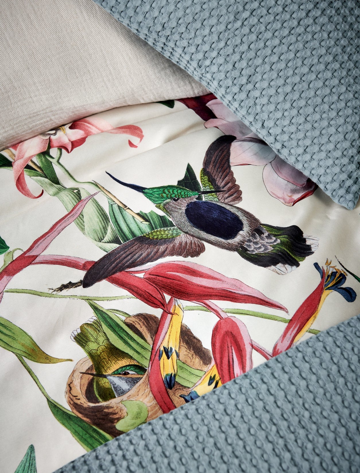 detail shot van een dekbedovertrek met bloemen en vogels met een beige achtergrondkleur