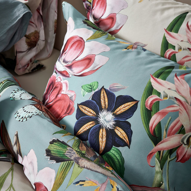detail shot van kussens in een blauw en beige kleur met bloemen en vogels