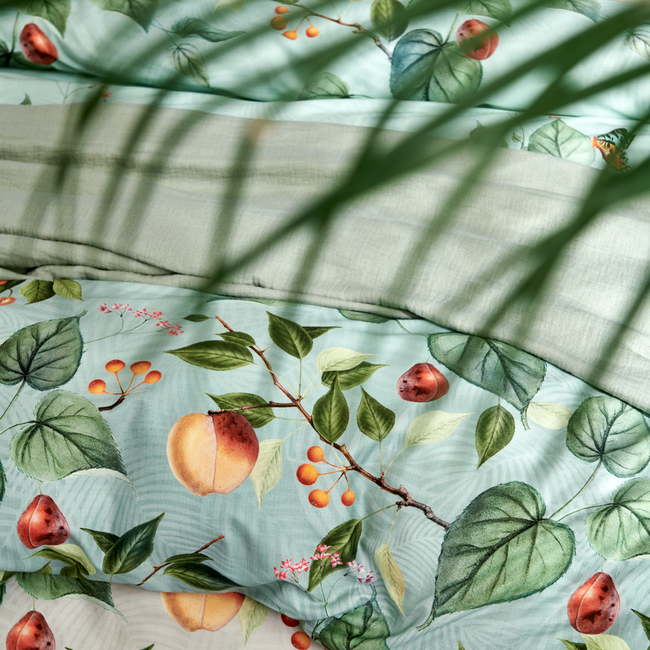 detail shot van een bed met bladeren, vruchten en vlinders op een lichtgroene en beige ondergrond