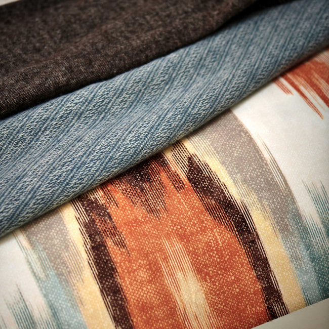 detail shot van een blauw sprei en een dekbedovertrek met print in oranje en blauwe kleuren
