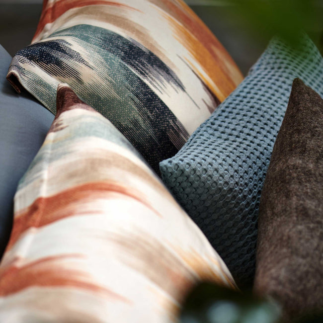 detail shot van hoofdkussens in een print met blauwe en oranje kleuren