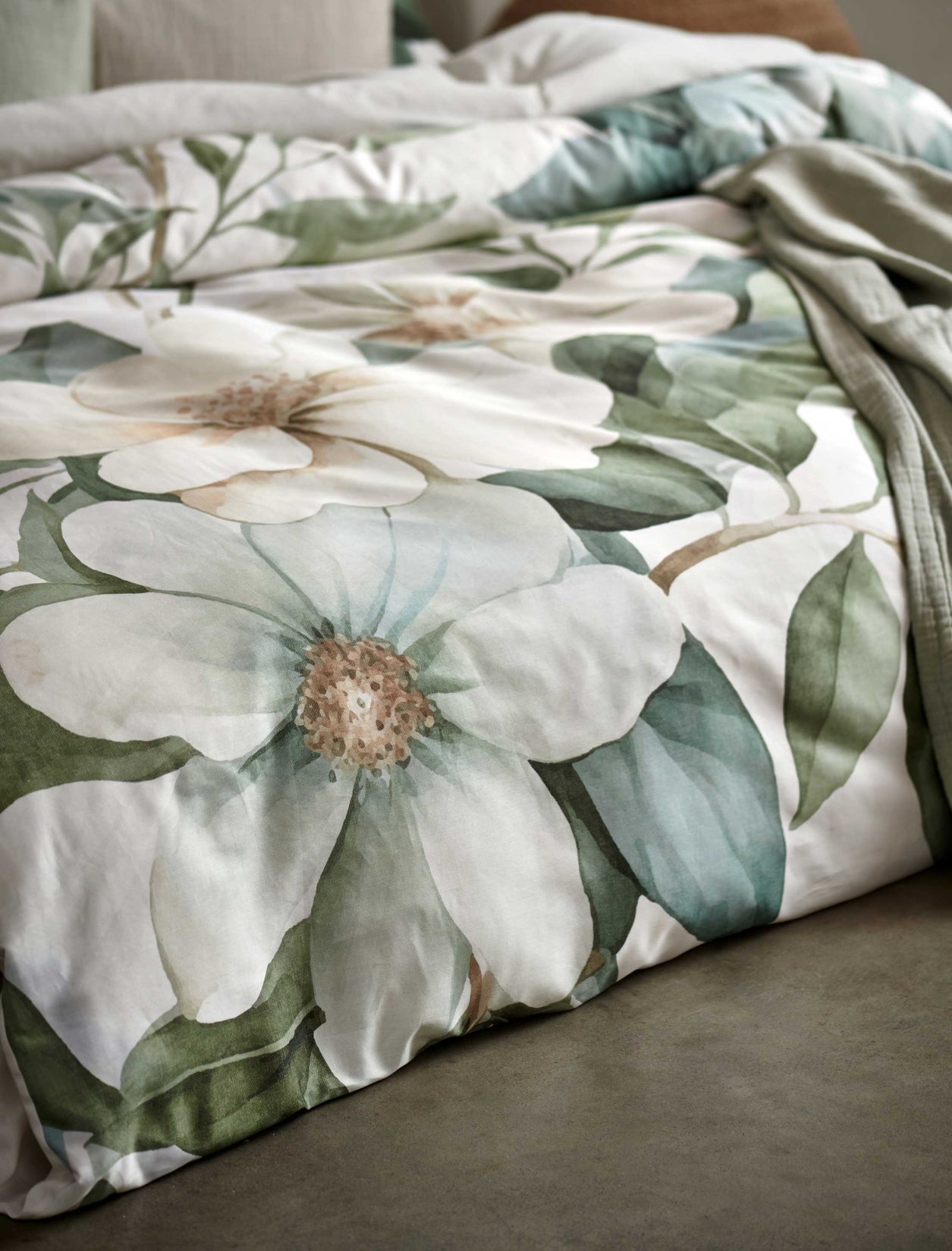 detail shot van een dekbedovertrek met groene en gele bladeren en bloemen