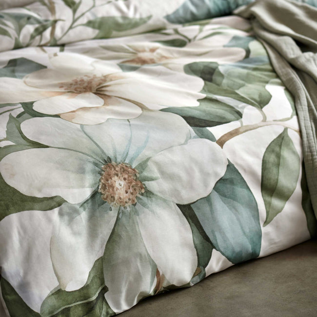 detail shot van een dekbedovertrek met groene en gele bladeren en bloemen