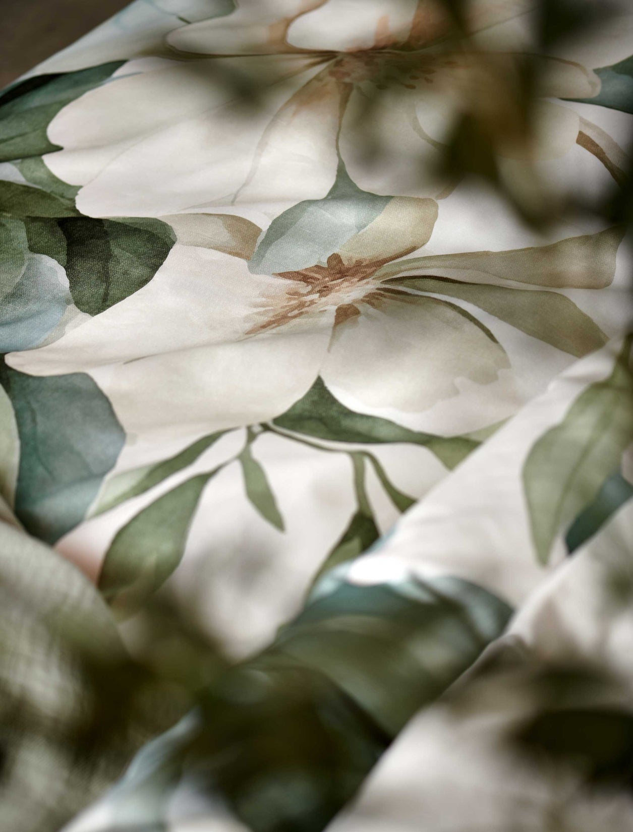 detail shot van een dekbedovertrek met groene en gele bloemen en groene bladeren