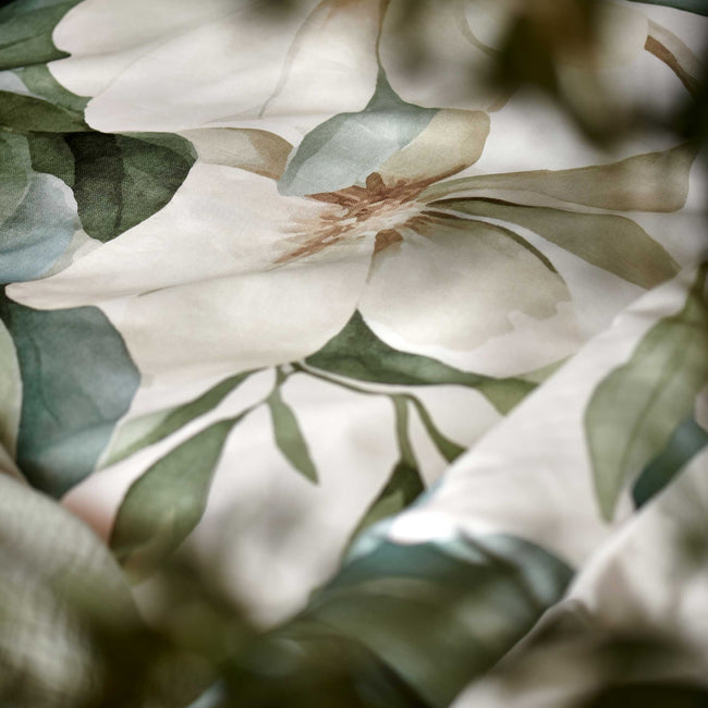 detail shot van een dekbedovertrek met groene en gele bloemen en groene bladeren