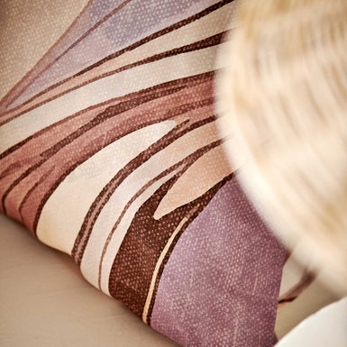 Swirls moonscape dekbedovertrek heeft een abstracte versie van een marmerpatroon met paars, roze en bruine tinten. De achterkant van het dekbedovertrek is effen offwhite. De kussens hebben aan beide zijden hetzelfde patroon. 