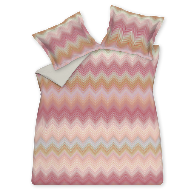 iggy pink dekbedovertrek heeft zigzaglijnen in verschillende tinten oranje, roze, blauw en groen. De achterkant van het dekbedovertrek is effen pastel groen. De kussens hebben aan beide zijdkanten dezelfde zigzaglijnen. Ziggy pink dekbedovertrek van Vandyck brengt rust en laat de buitenwereld vervagen, alsof je door wazige ramen van de ochtenddauw naar buiten probeert te kijken en alleen vage omlijningen ziet. 