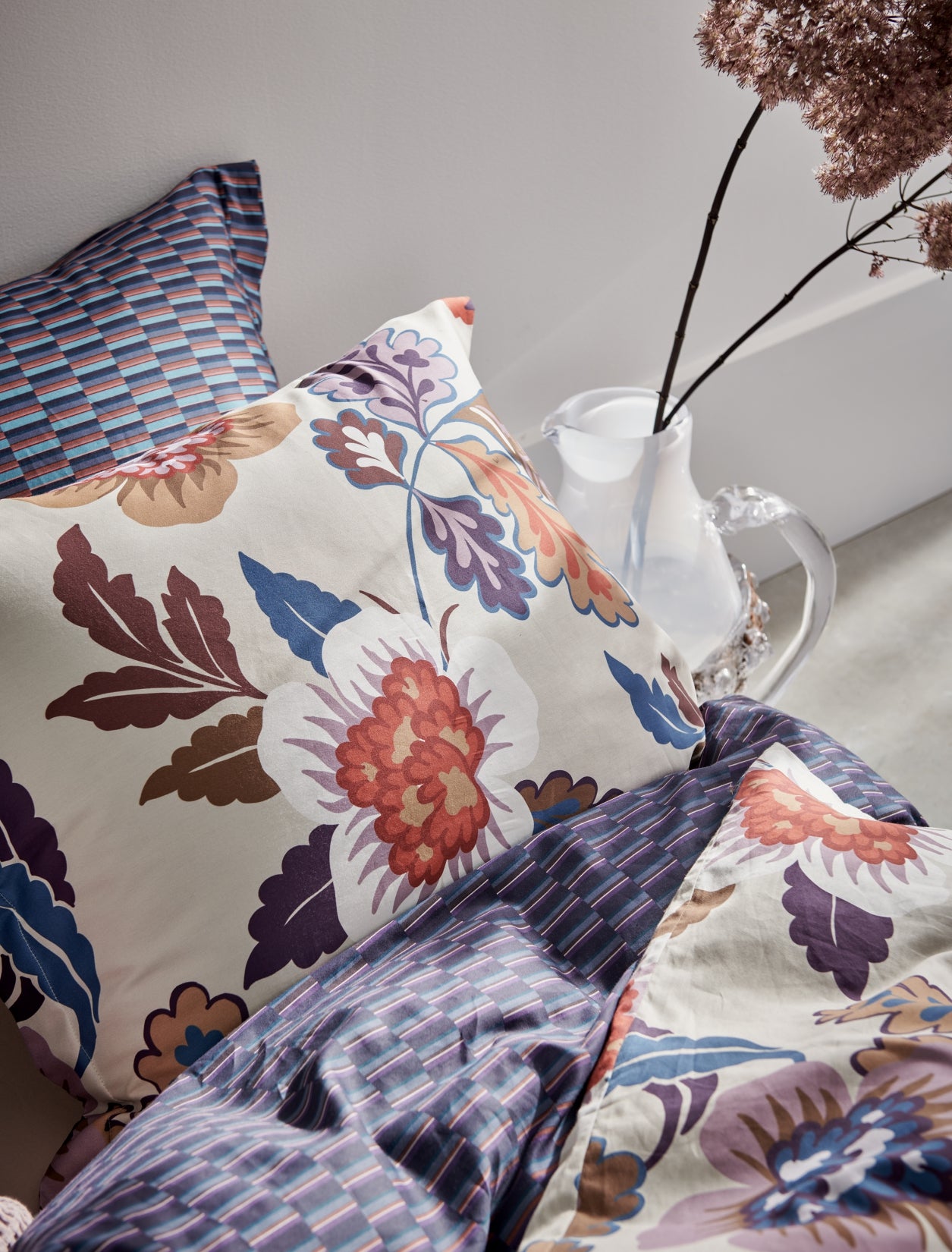 detail shot van een dekbedovertrek met een grafische print in rode en blauwe kleuren en een dekbedovertrek met bloemen in blauw en rode kleuren