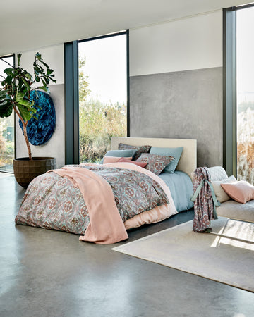 een bed in een rustige setting in blauwe en roze tinten