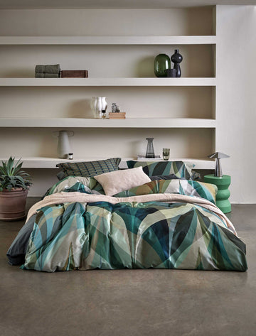 een bed in een rustige omgeving met een dekbedovertrek met strepen en een print in groene en beige kleuren