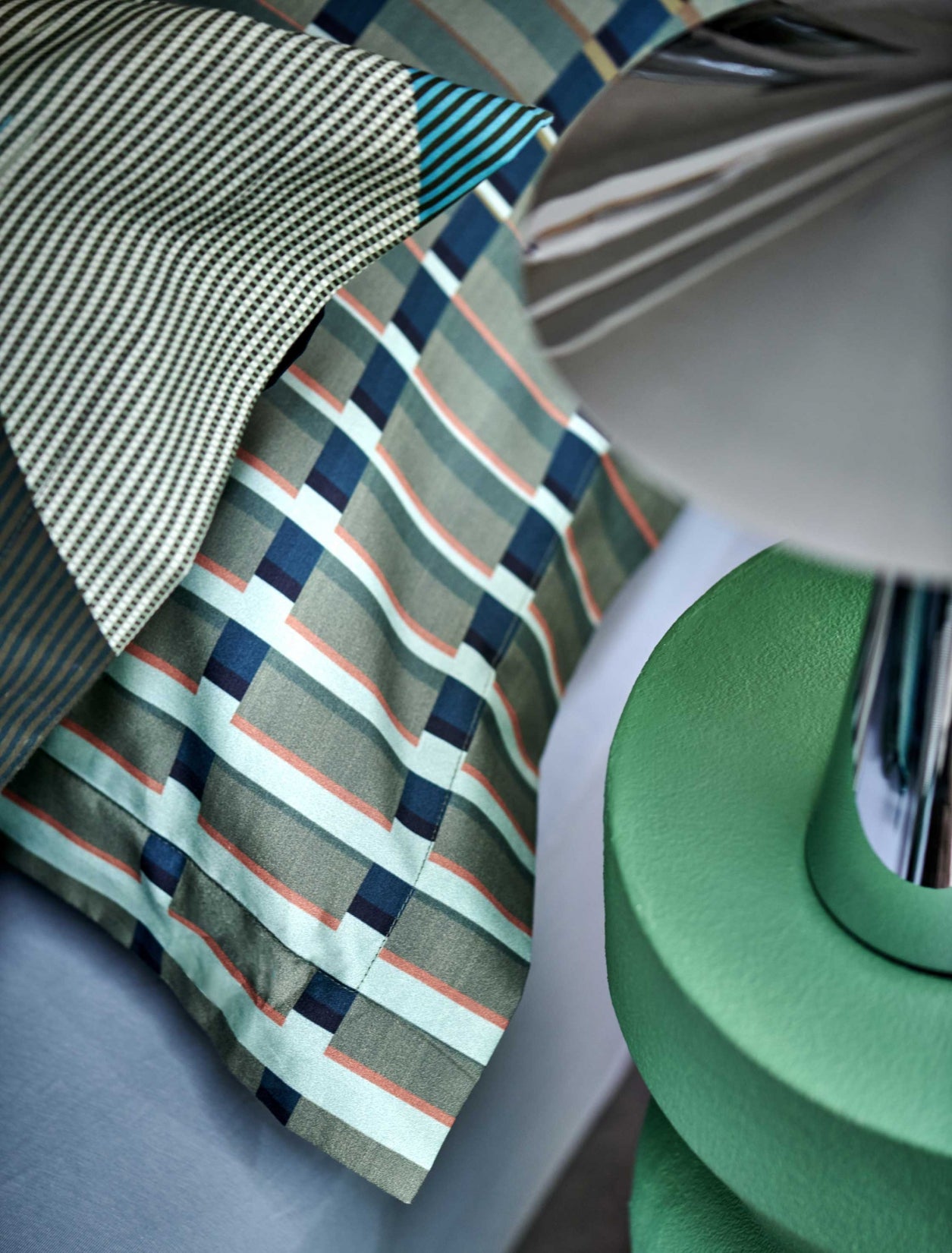 detail shot van een hoofdkussen met strepen in groene en blauwe kleuren