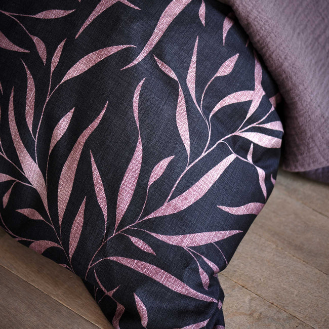detail shot van een dekbedovertrek met bladeren in paarse en roze kleuren