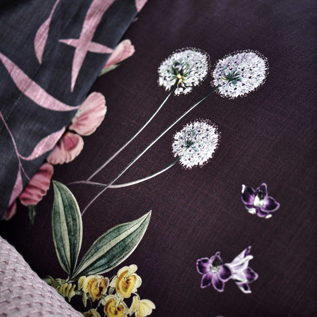 detail shot van een hoofdkussen met bloemen in paarse kleuren