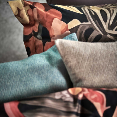 detail shot van een bed met een kussensloop met bloemen en sierkussens in de blauwe en bruine kleuren