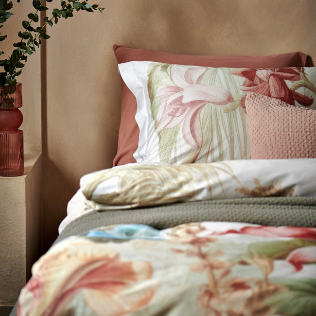 Florentine multi dekbedovertrek heeft enorme bloemen en bladeren in rood, blauw, oranje, groen en bruine tinten op een off white achtergrond, waarbij de tinten een soort sepia gloed lijken te hebben. De achterkant van het dekbedovertrek is effen beige.