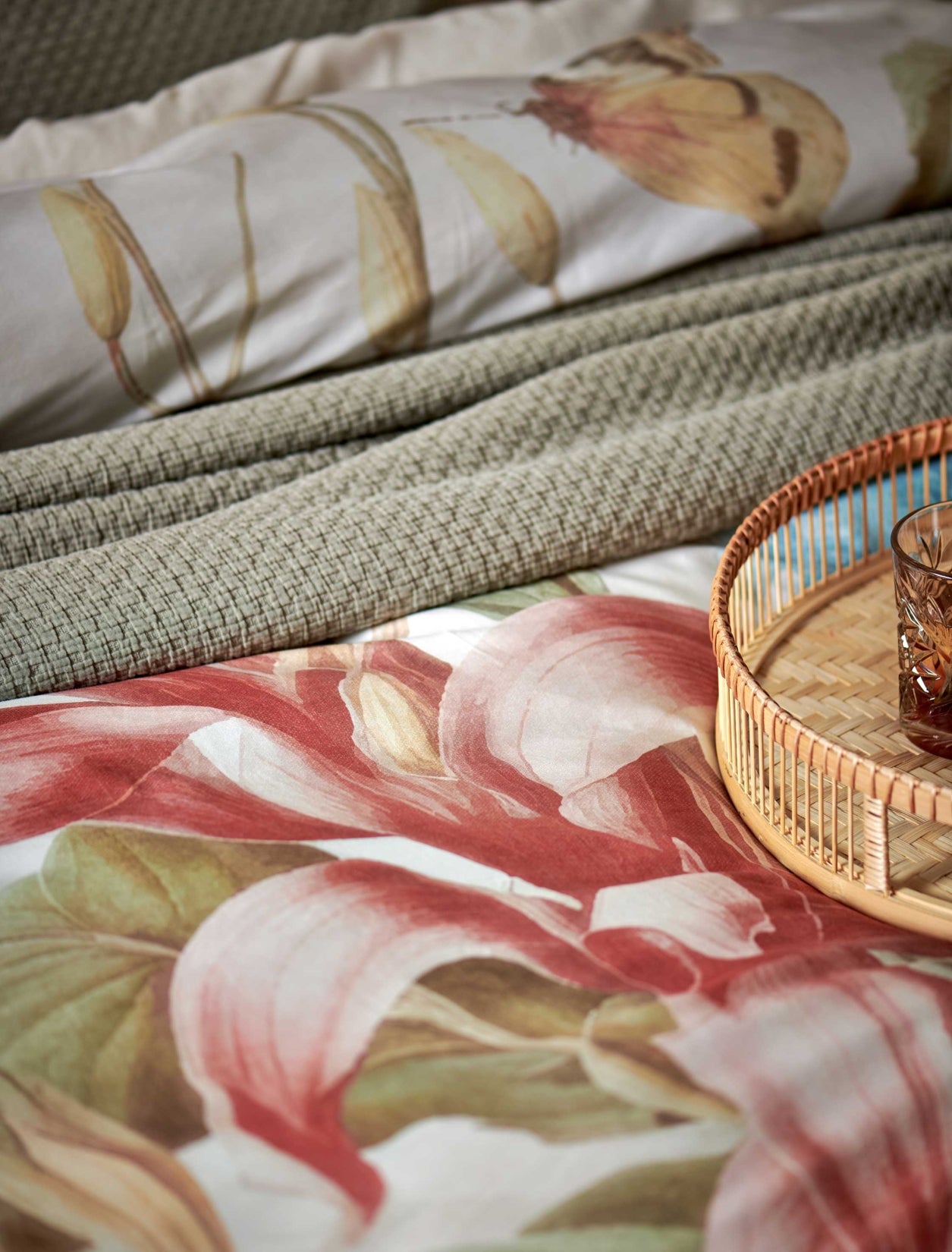 Florentine multi dekbedovertrek heeft enorme bloemen en bladeren in rood, blauw, oranje, groen en bruine tinten op een off white achtergrond, waarbij de tinten een soort sepia gloed lijken te hebben. De achterkant van het dekbedovertrek is effen beige.