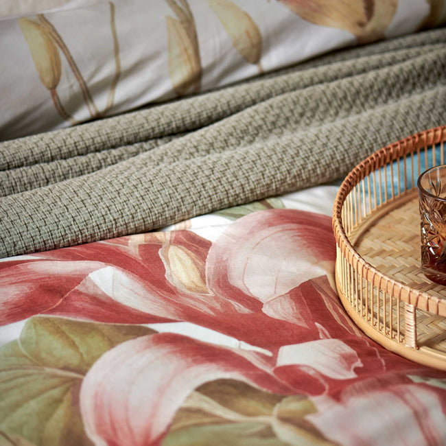 Florentine multi dekbedovertrek heeft enorme bloemen en bladeren in rood, blauw, oranje, groen en bruine tinten op een off white achtergrond, waarbij de tinten een soort sepia gloed lijken te hebben. De achterkant van het dekbedovertrek is effen beige.