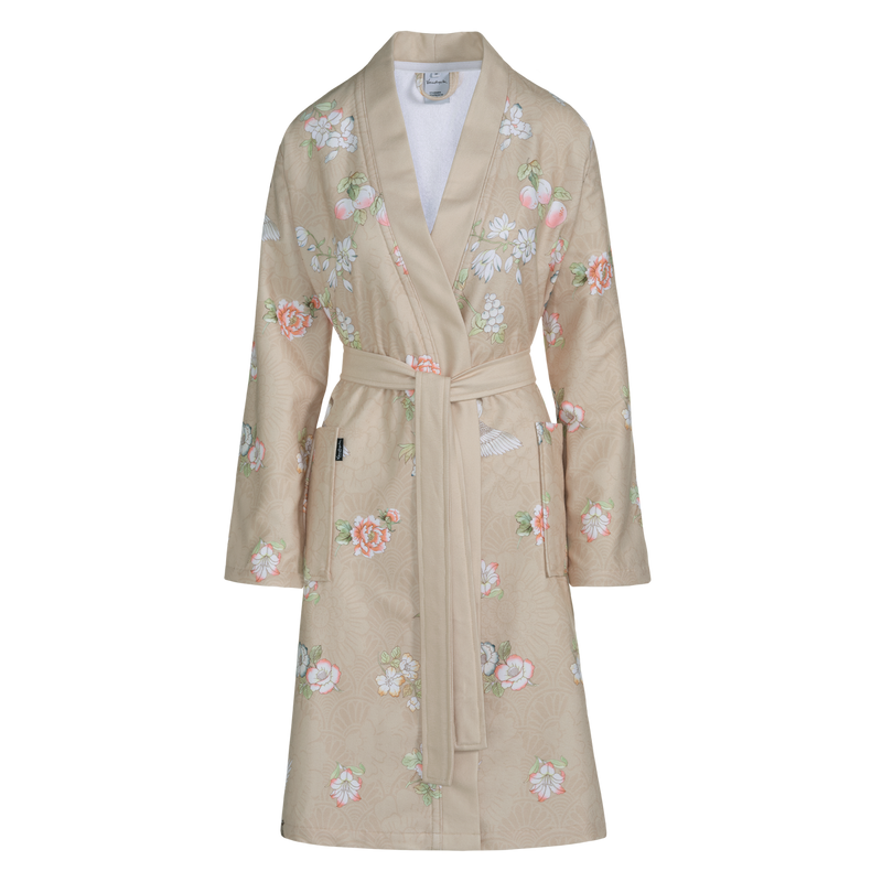 Dakota sand badjas heeft een gekleurde bloemenprint op zandkleurige achtergrond. De badjas heeft een brede kraag, grote insteekzakken en is geschikt voor dames.
